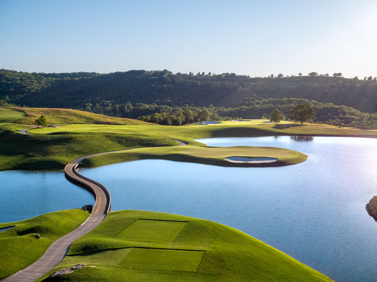 Payne's Valley Hole 5 par 3 over water framed by native limestone and Ozark forest